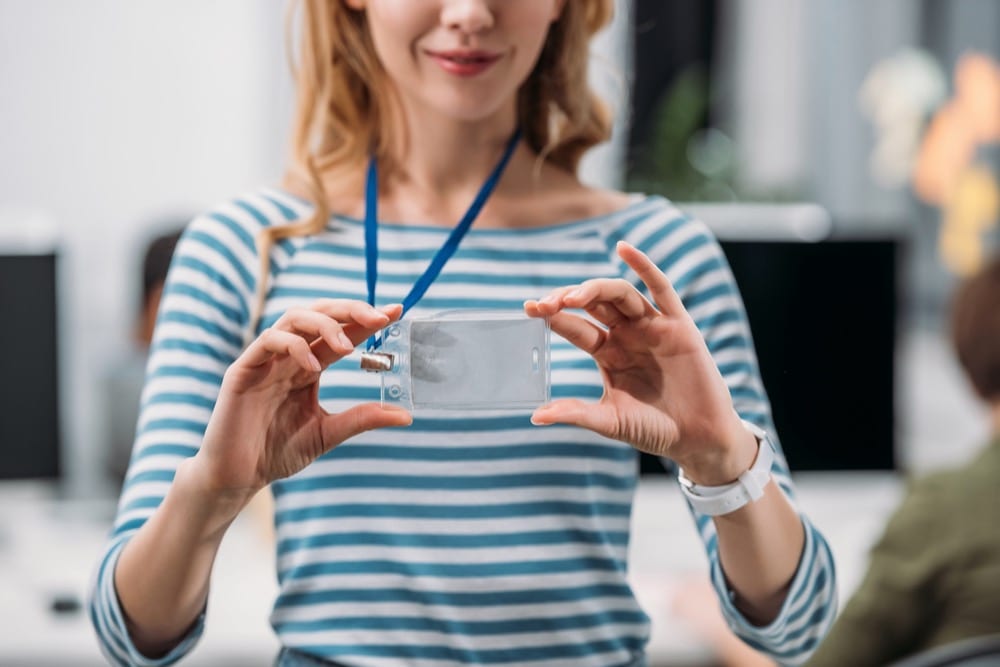 Woman holding a printed ID badge